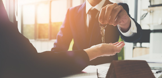 Man handing over the keys to a new homebuyer.